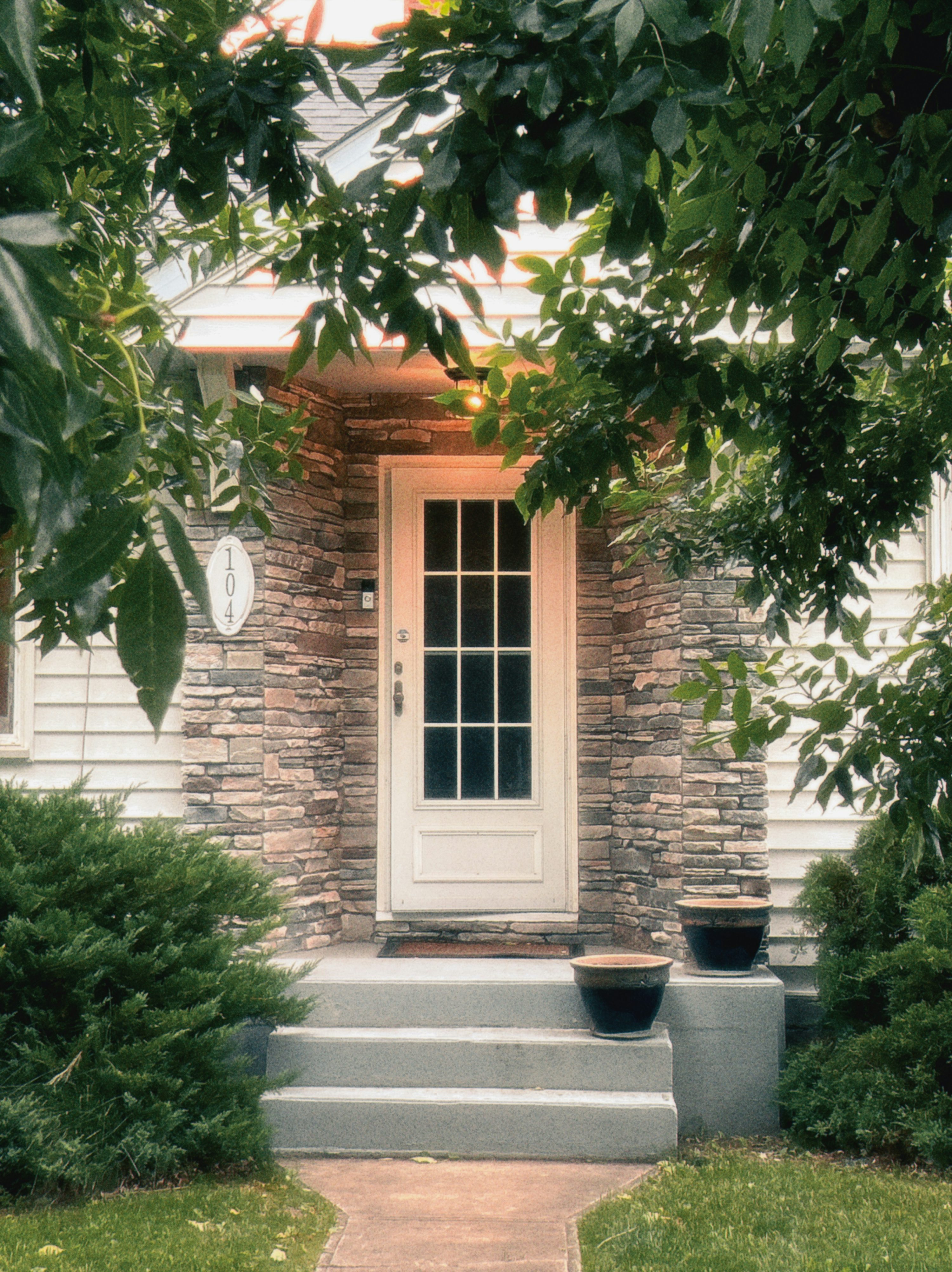 A welcoming residential entrance framed by stone and greenery